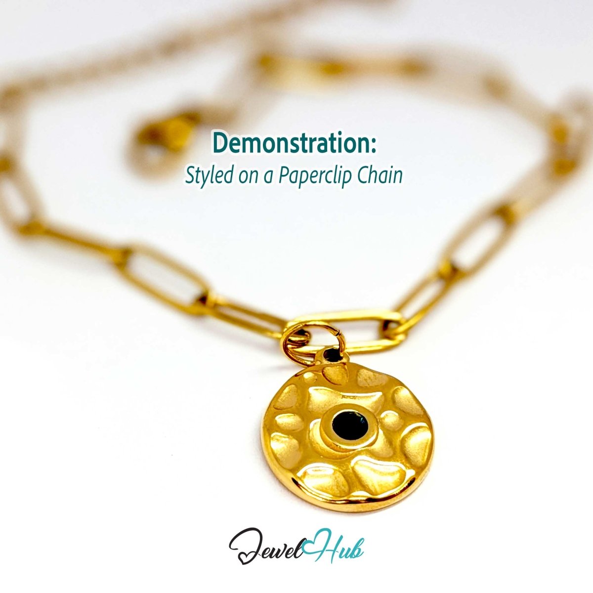Hammered disc charm in gold stainless steel with a green stone - styled on a gold paperclip chain bracelet - JewelHub