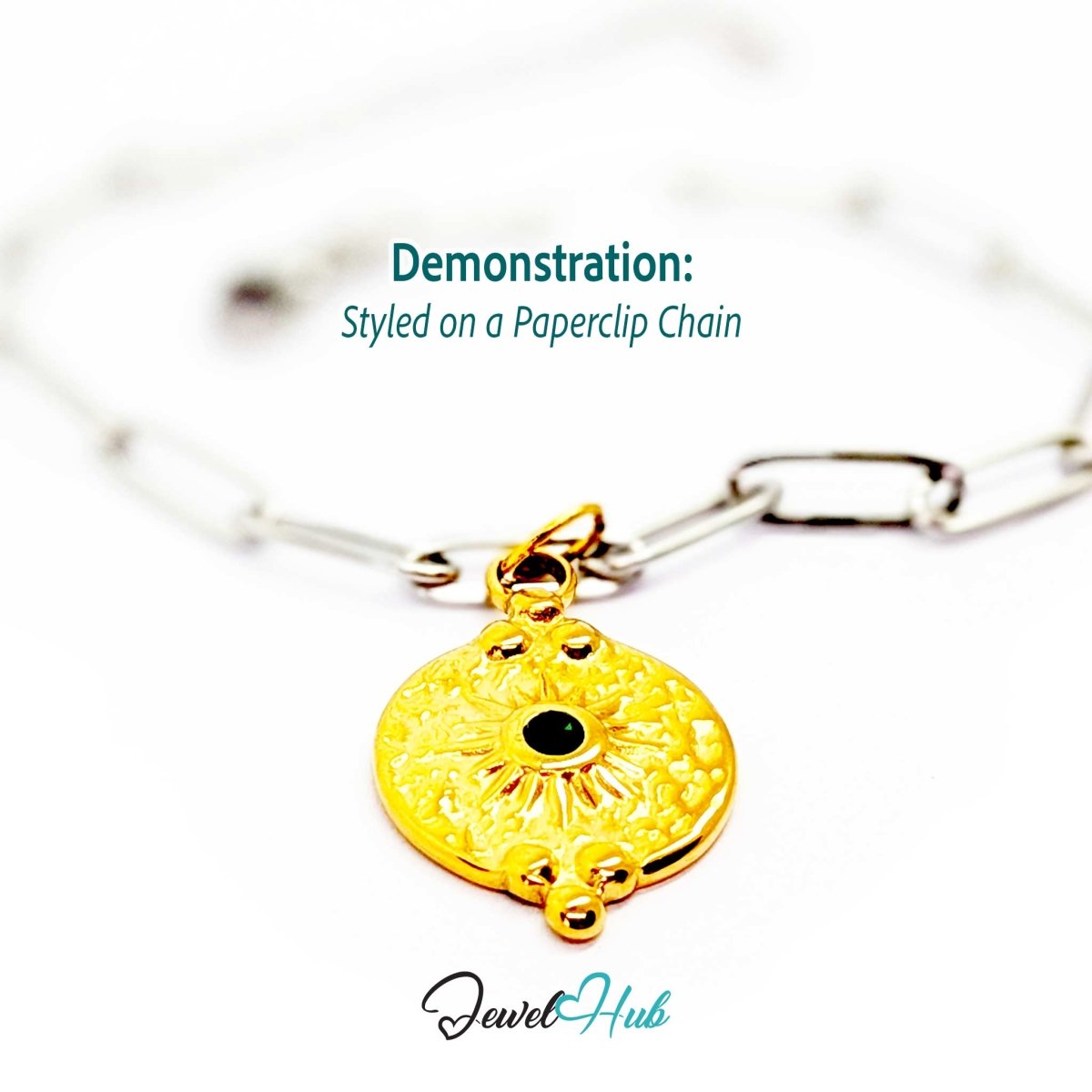 Rosette medallion charm in gold stainless steel with a green gem - styled on a silver paperclip chain bracelet - JewelHub
