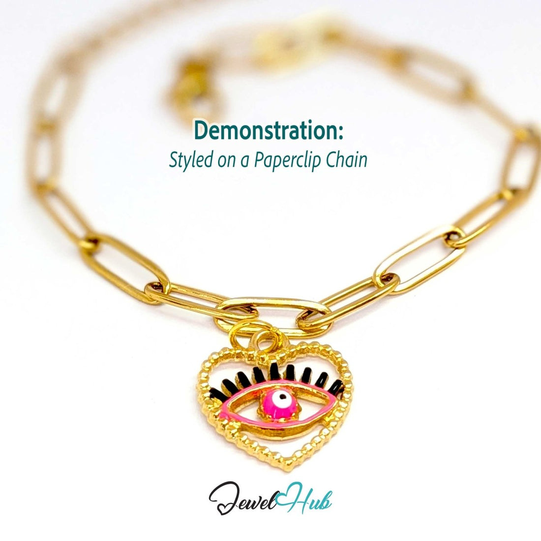 Pink Hollow Evil Eye charm, gold stainless steel with enamel, styled on a gold paperclip chain bracelet - JewelHub