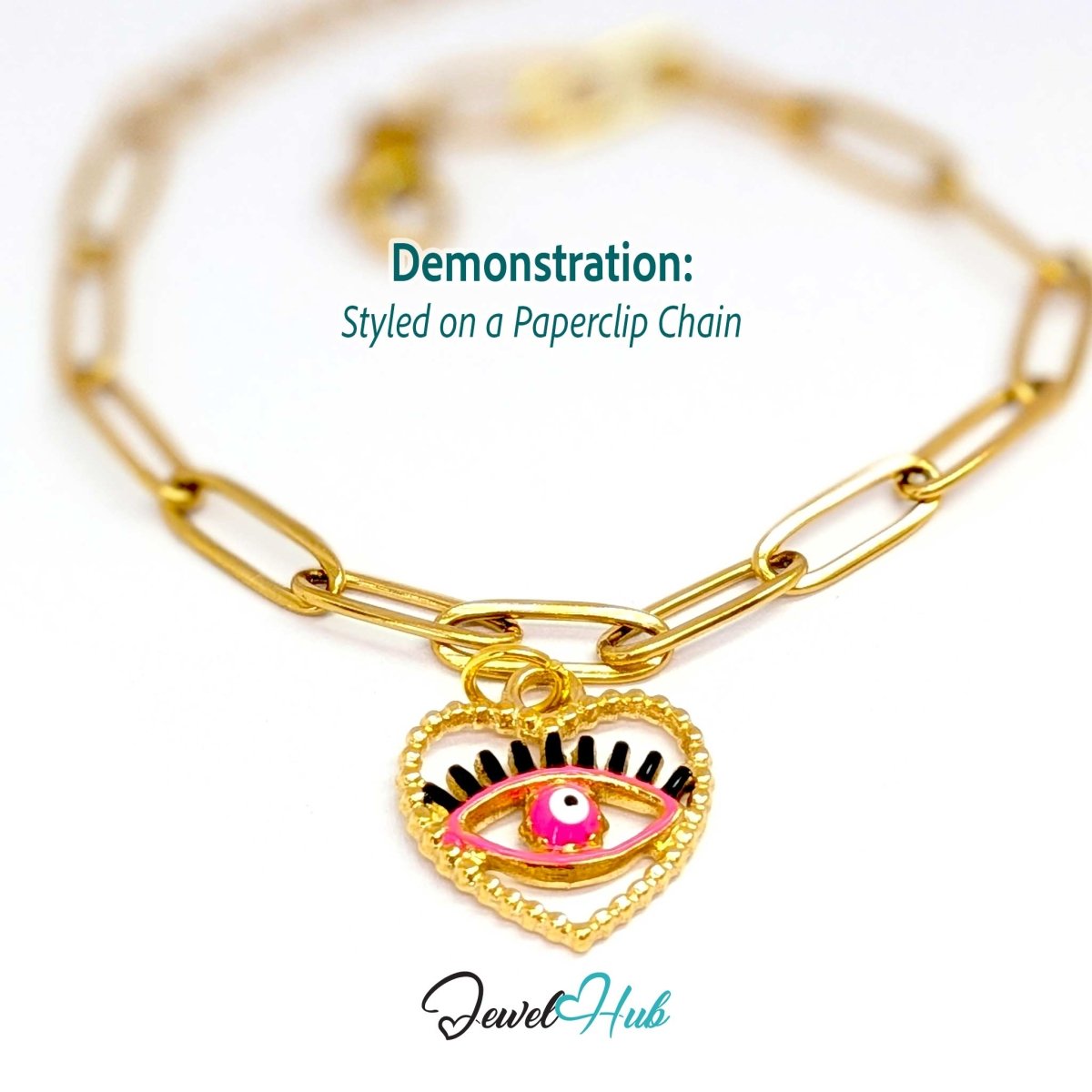 Pink Hollow Evil Eye charm, gold stainless steel with enamel, styled on a gold paperclip chain bracelet - JewelHub