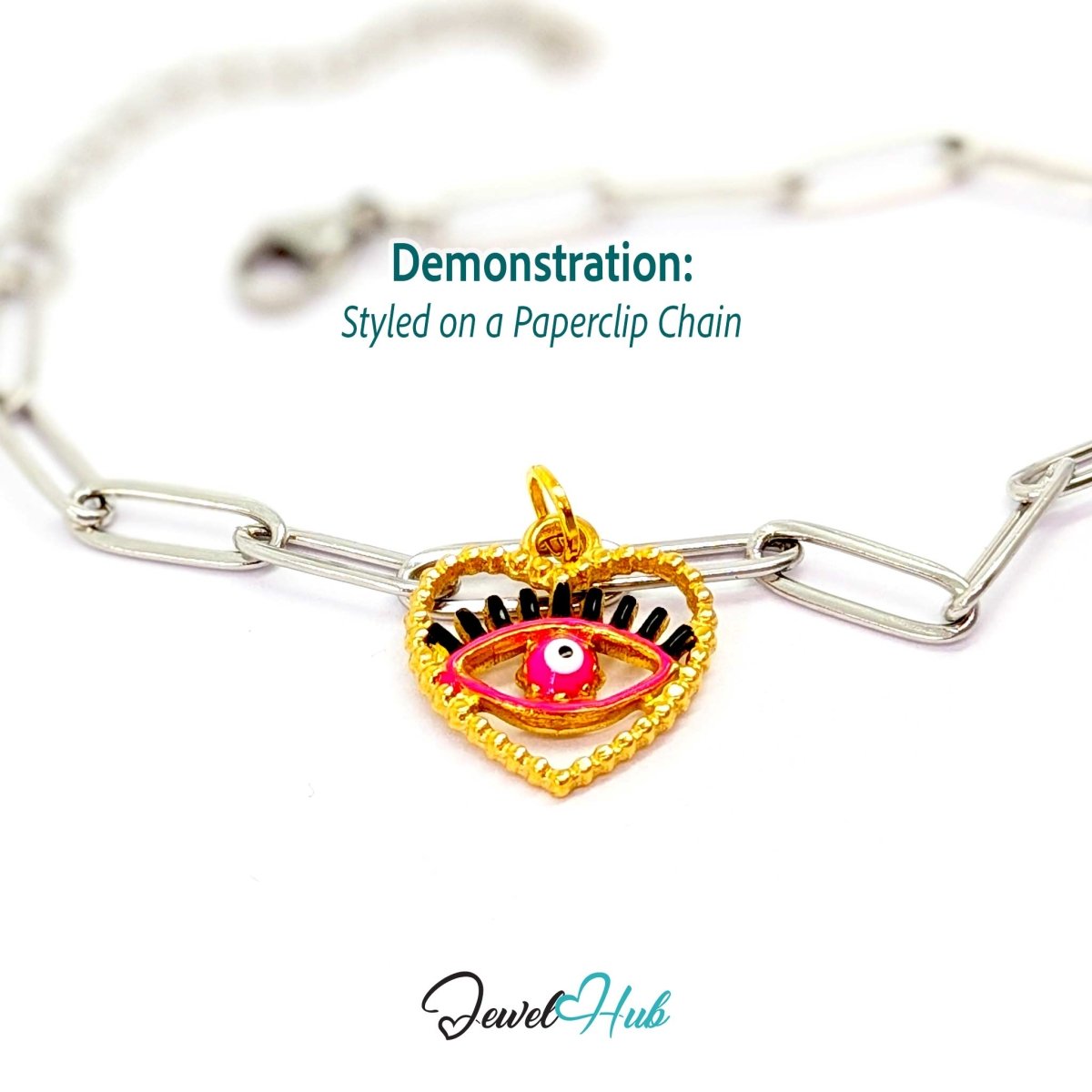 Pink Hollow Evil Eye charm, gold stainless steel with enamel, styled on a silver paperclip chain bracelet - JewelHub