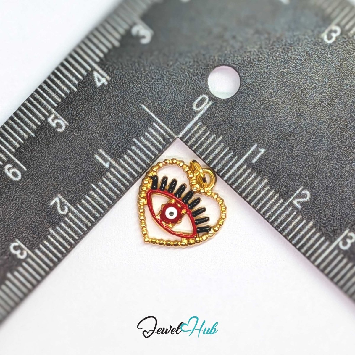 Red Hollow Evil Eye charm, gold stainless steel with enamel, measured against a ruler at 15.2 x 16mm - JewelHub