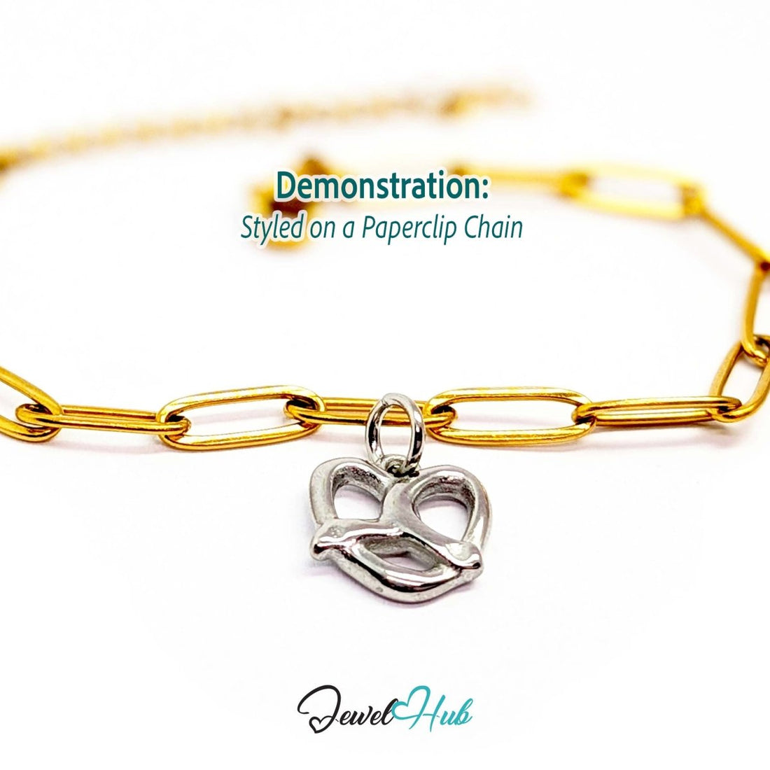 Openwork pretzel charm in silver stainless steel - styled on a gold paperclip chain bracelet - JewelHub
