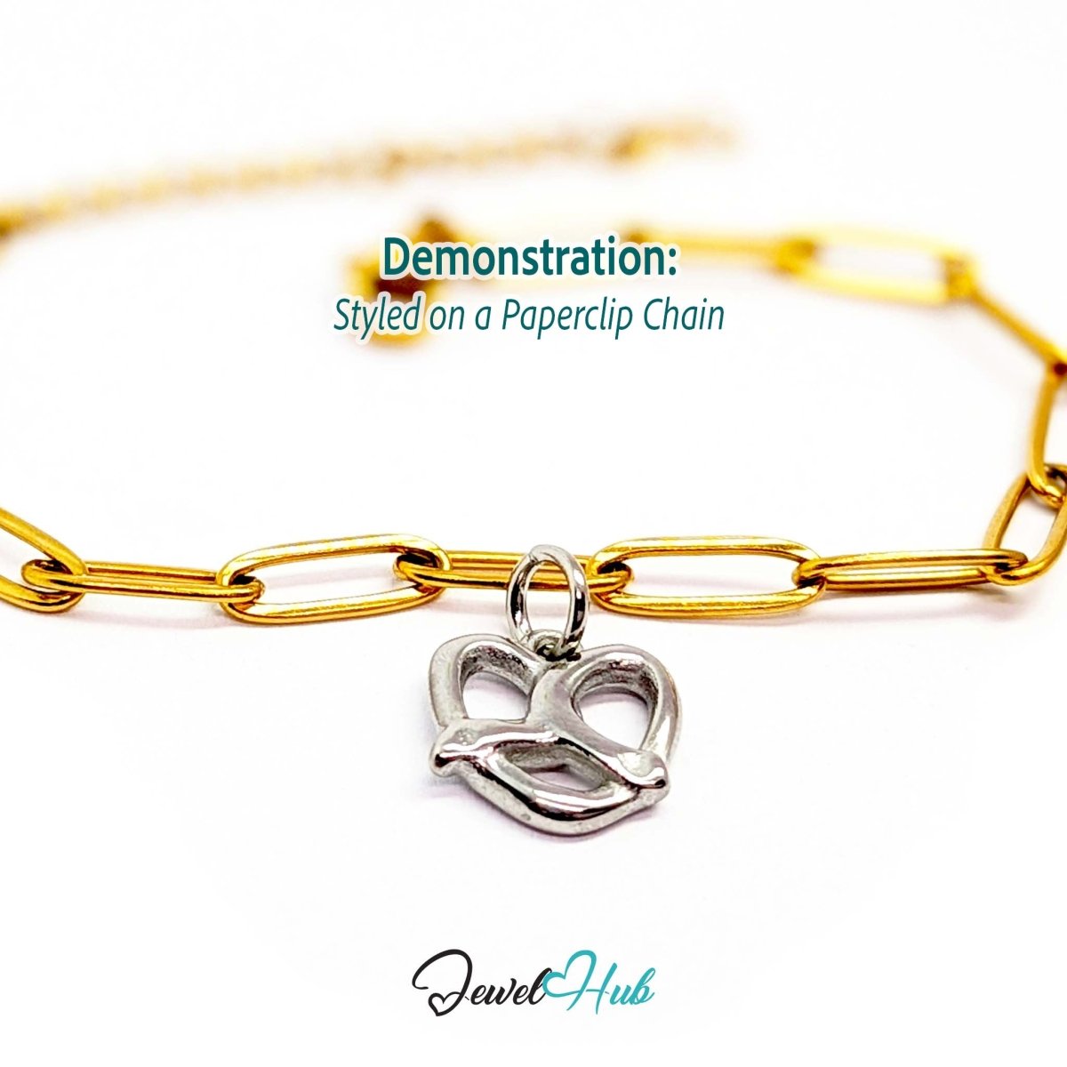 Openwork pretzel charm in silver stainless steel - styled on a gold paperclip chain bracelet - JewelHub