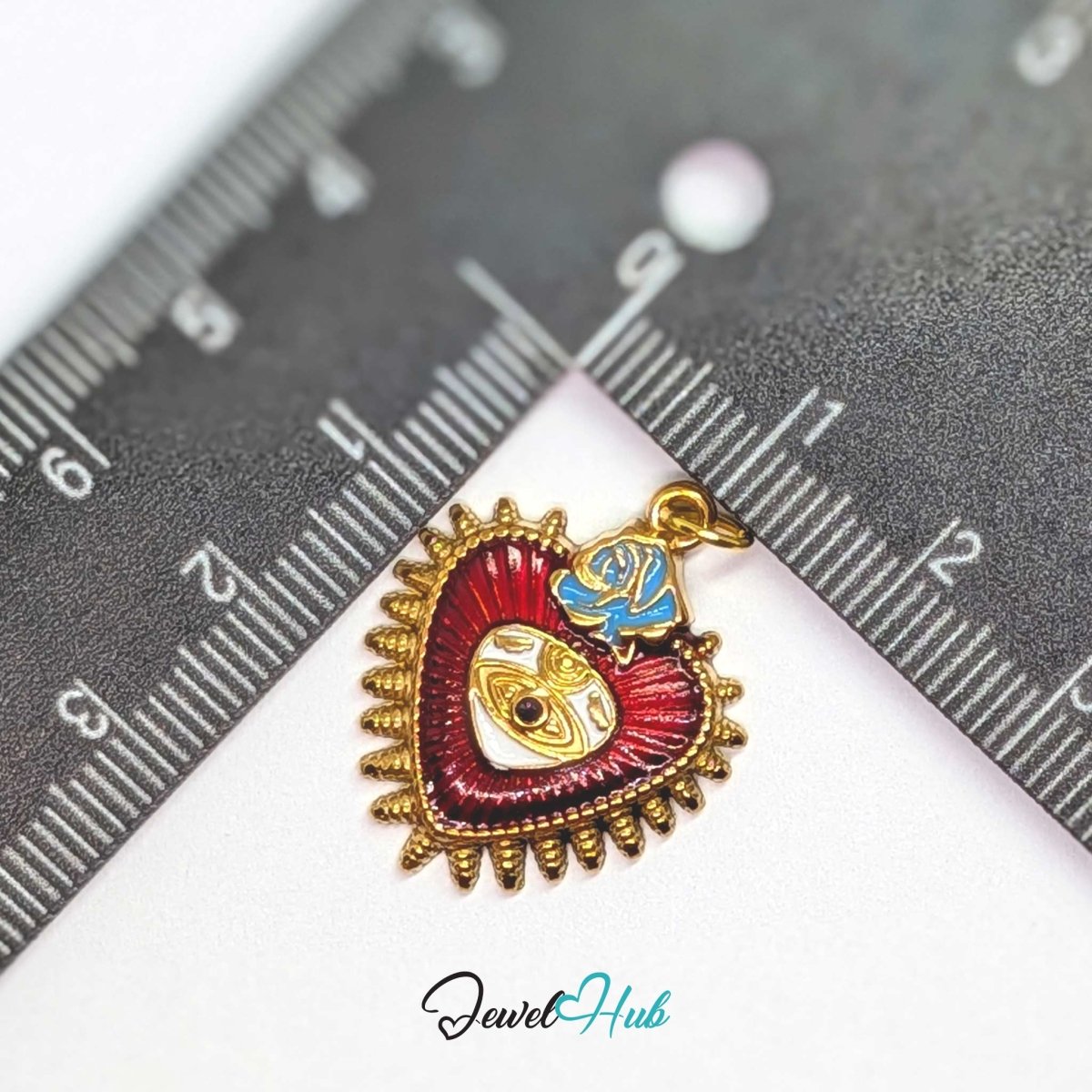Sacred Heart Evil Eye charm, gold stainless steel, measured against a ruler at 21 x 26mm - JewelHub