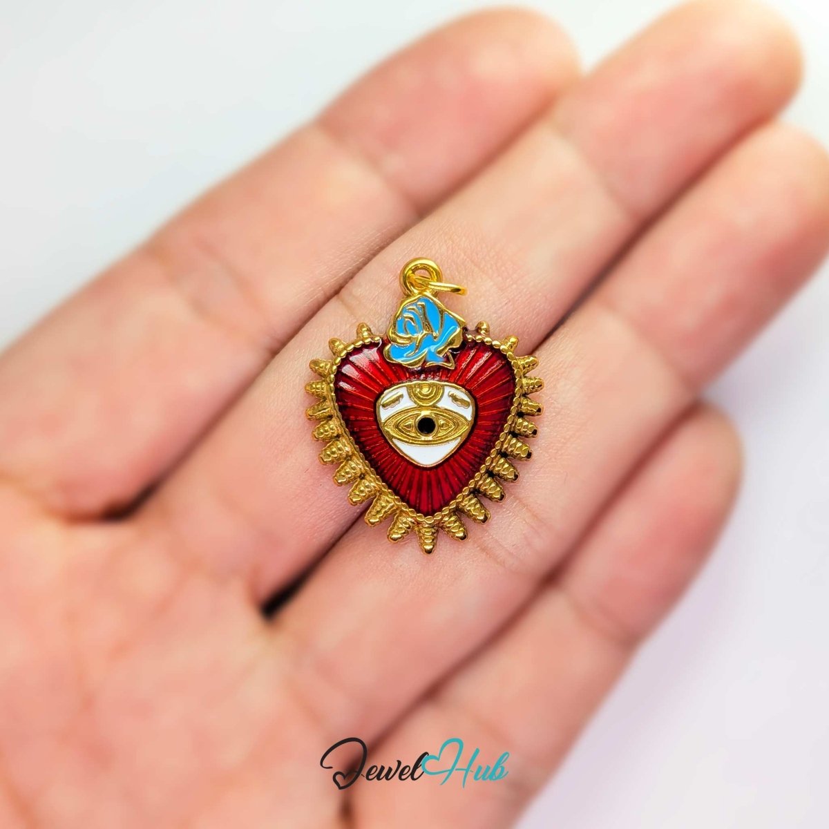 Sacred Heart Evil Eye charm, gold stainless steel, held in the hand to show its size - JewelHub