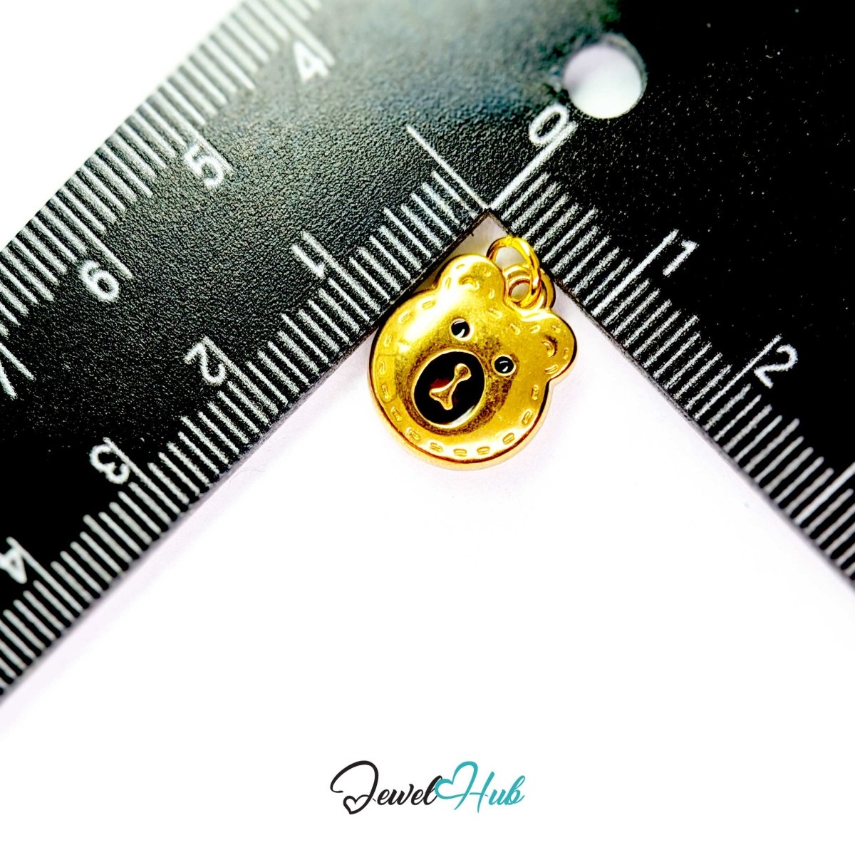 Gold Stitched Bear Head charm measured against a ruler at 12mm wide by 16mm tall - JewelHub