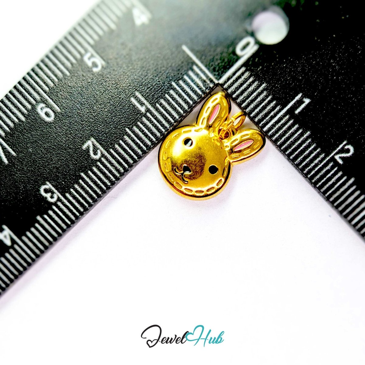 Gold Stitched Bunny Head charm measured against a ruler at 12.5mm wide by 16.5mm tall - JewelHub