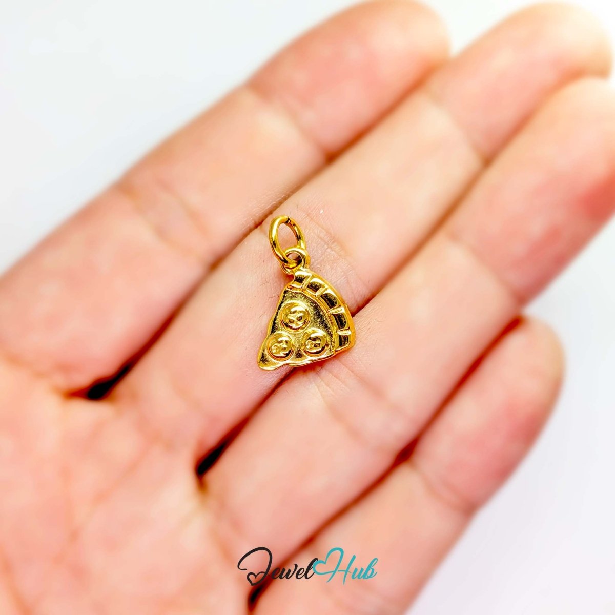 Three topping pizza slice charm in gold stainless steel - held in the hand for scale - JewelHub
