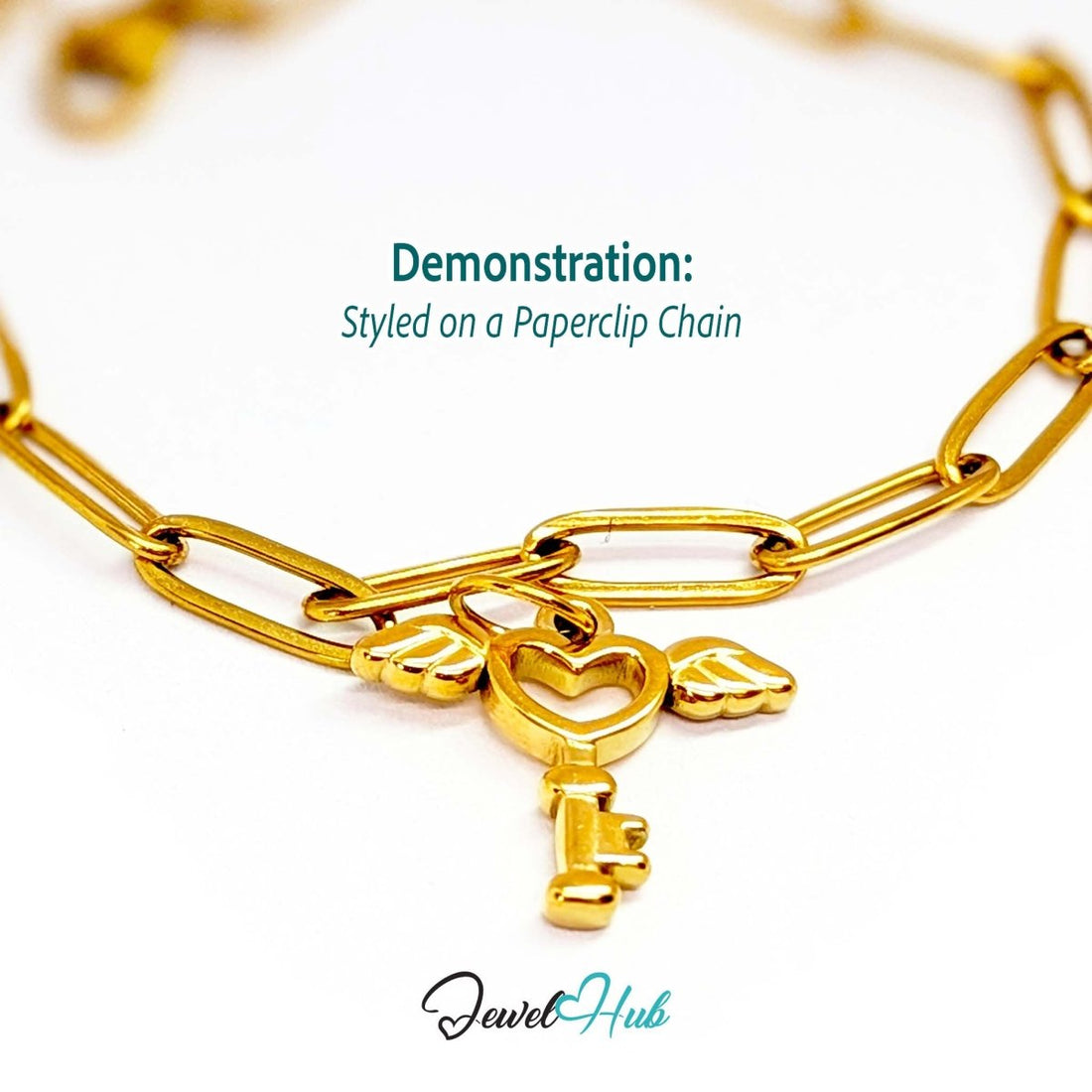 Winged heart key charm in gold stainless steel - styled on a gold paperclip chain bracelet - JewelHub